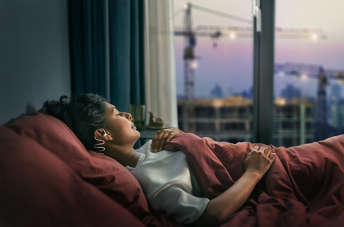 Couple sleeping, with the woman wearing Philips Sleep Headphones