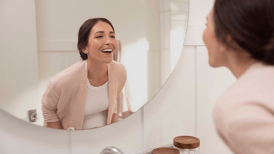 Woman inspecting teeth in mirror