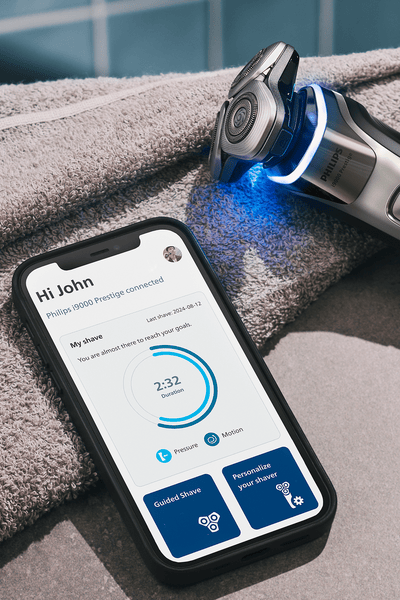 A razor and next to it a display of the Male Grooming App, lying on the table