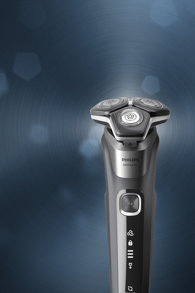 Philips electric shaver standing upright on a blue background, showcasing a sleek design and rotary shaving head for a close, comfortable shave.