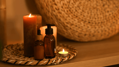 recipiente cu masti de par langa o lumanare aprinsa