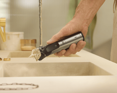 Trimmer being rinsed under running water