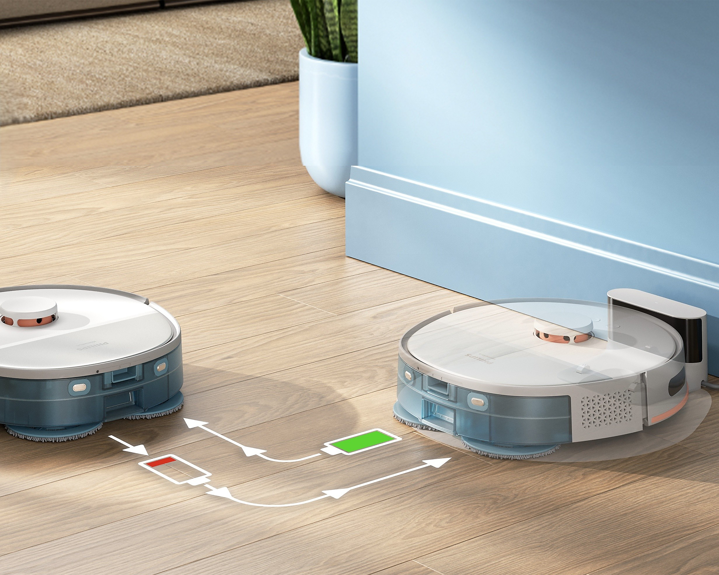 Divi roboti putekļsūcēji pie dokstacijas, redzama akumulatora uzl...