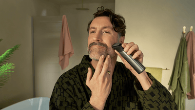 Чоловік підтригає бороду універсальним тримером