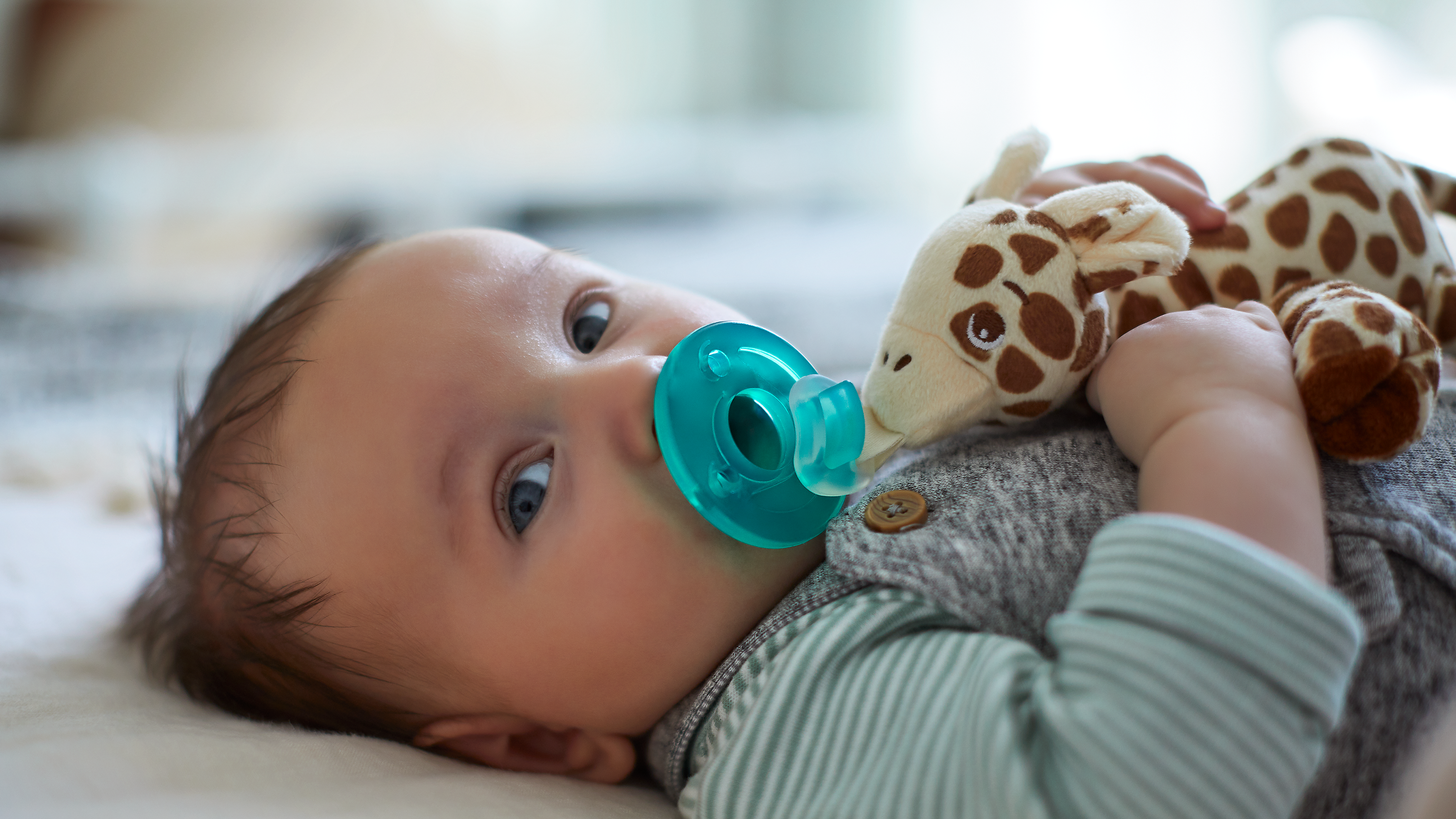 Baby smiling while holding a snuggle