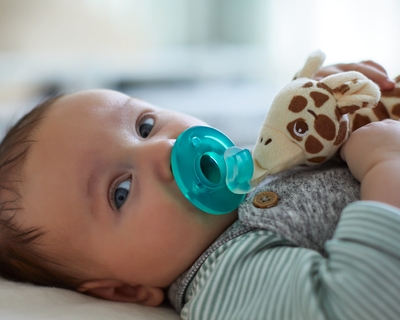 Baby smiling while holding a snuggle