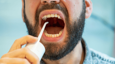 Muž pomocí mezizubního zařízení.