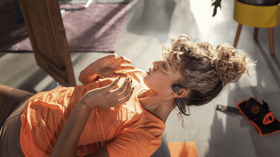 Športovec používajúci slúchadlá s otvoreným uchom pri cvičení v interiéri