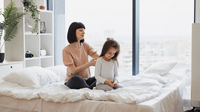 Matka delikatnie czesze włosy swojej córki.