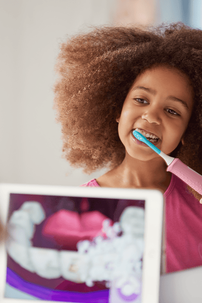 Girl using a Sonicare For Kids power toothbrush
