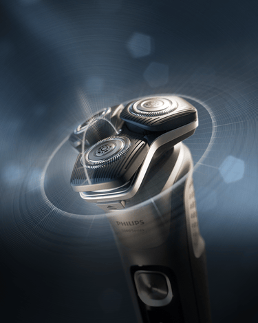 Philips rotacioni električni aparat za brijanje sa svetlećim glavama i elegantnim ergonomskim dizajnom na tamnoplavoj pozadini.