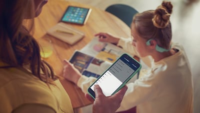 Rodič používá aplikaci Philips Headphones k ovládání hlasitosti dětských sluchátek