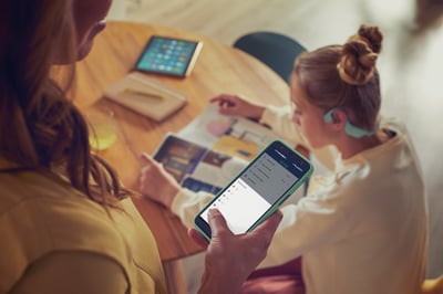 Een ouder gebruikt de Philips Headphones-app om het volume van de kinderkoptelefoon te regelen