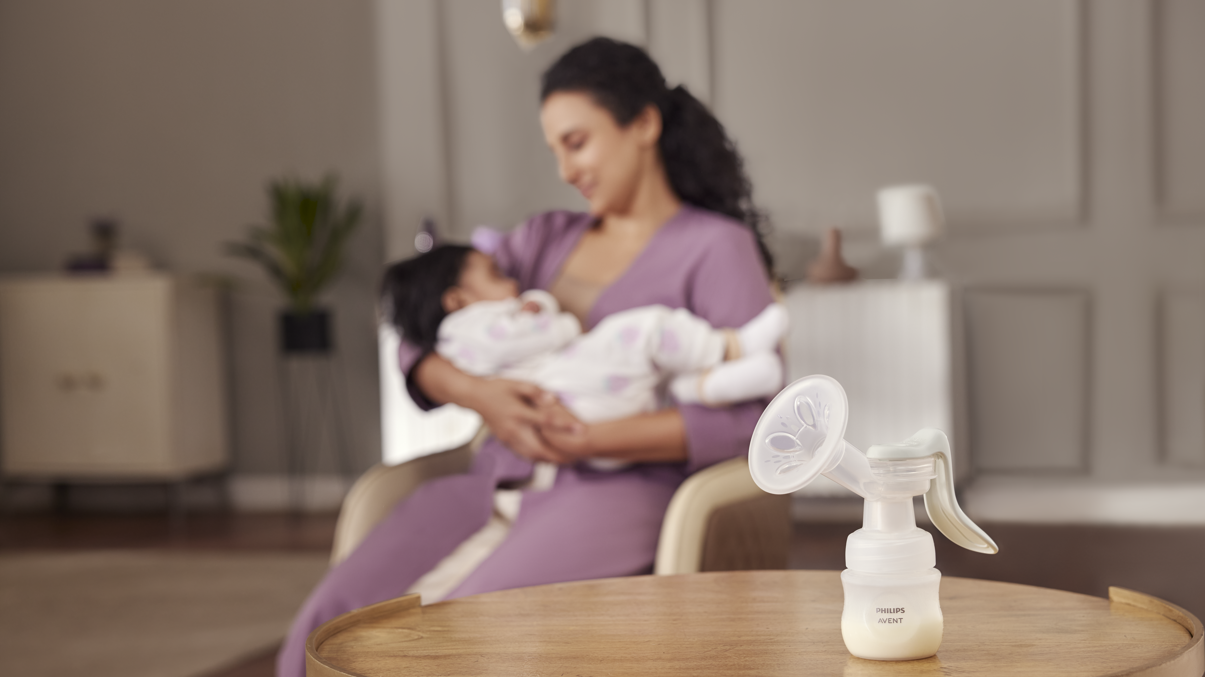 Mãe na cama com o bebê extraindo leite