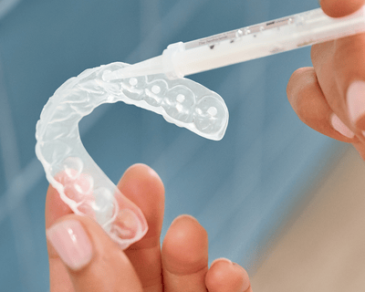 Hand die een bleeklepel met gel vult