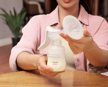 Mãe na cama bombeando com o bebê