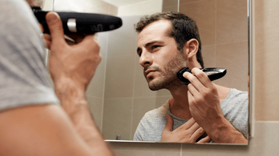 גבר גוזם זקן מול מראה