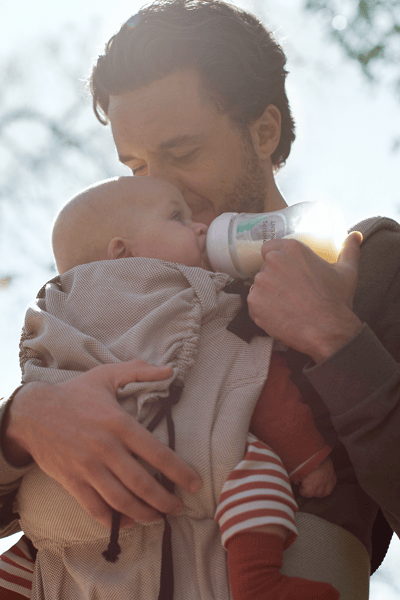 man bottle-feeding a baby