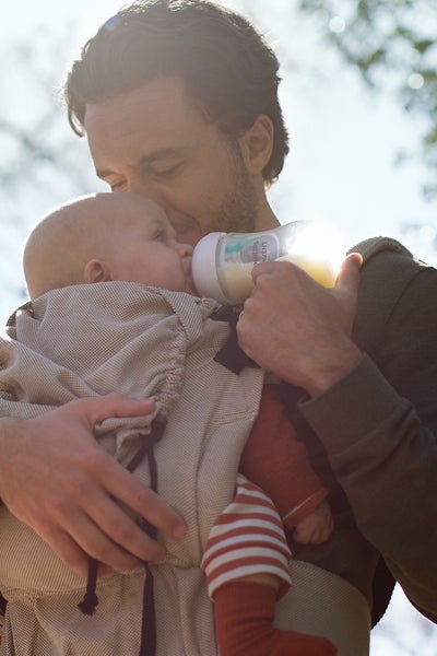 man bottle-feeding a baby