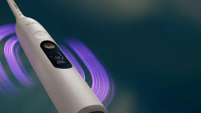A white Philips Next-Generation DiamondClean electric toothbrush against a dark gradient background.
