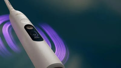A white Philips Next-Generation DiamondClean electric toothbrush against a dark gradient background.