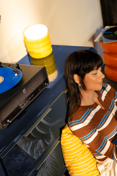 En kvinde, der lytter til musik på et Philips Home Audio-system.