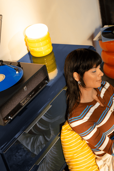 Een vrouw luistert naar muziek op een Philips home audio systeem.