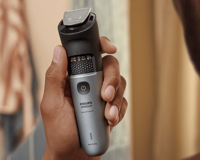 Man holds waterproof Beard Trimmer 7000 in shower