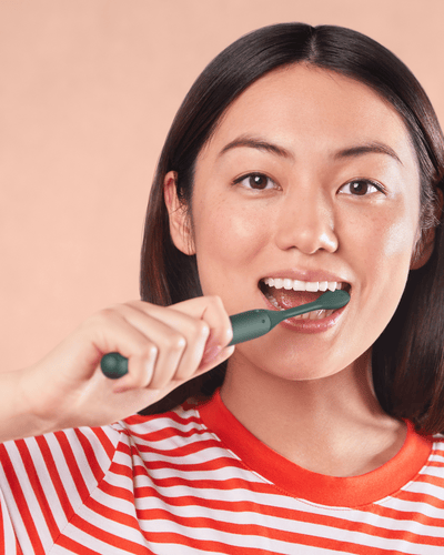Woman brushing teeth with electric toothbrush