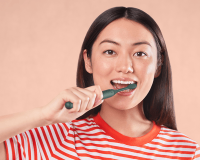 Woman brushing teeth with electric toothbrush