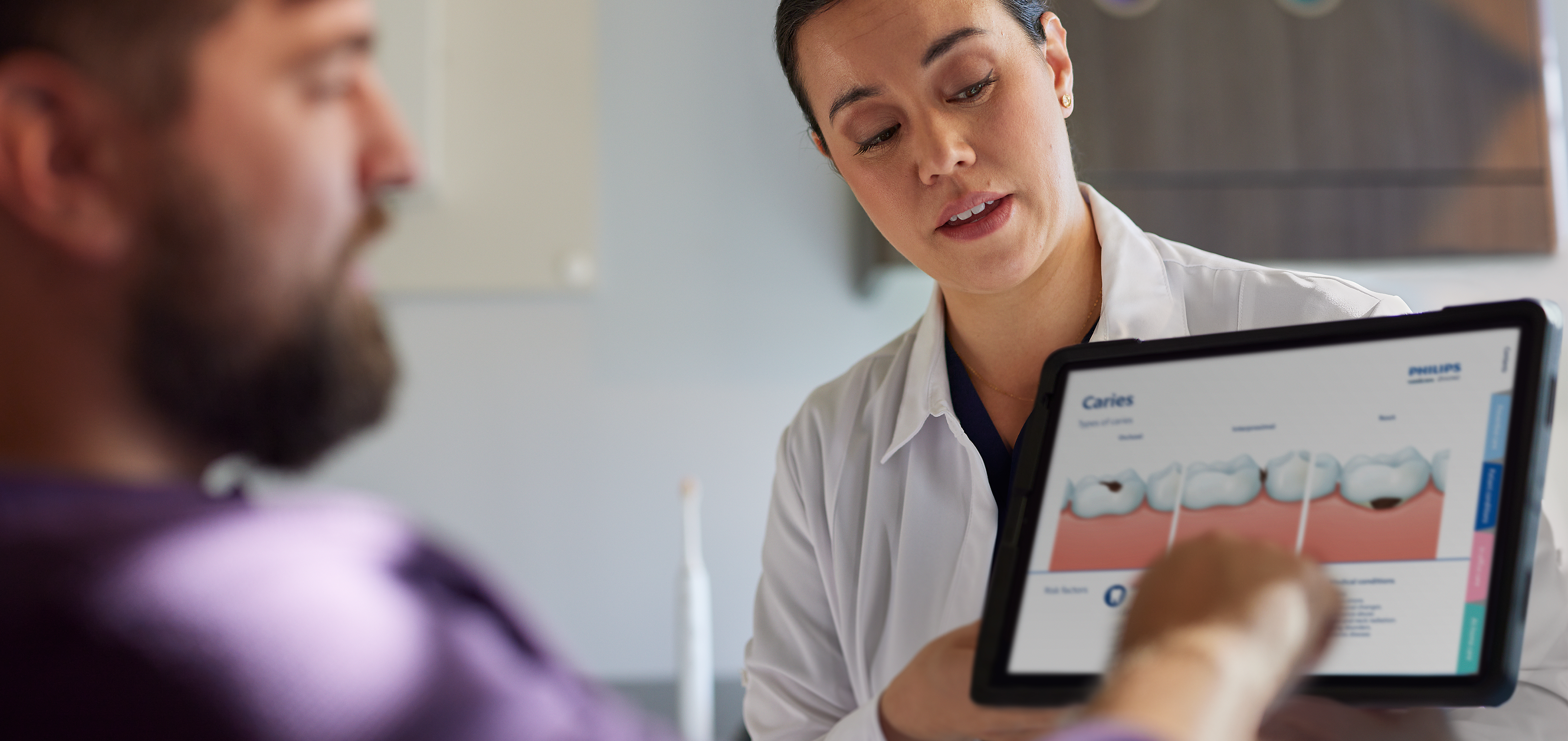 A dental professional holding the guide talks with patient