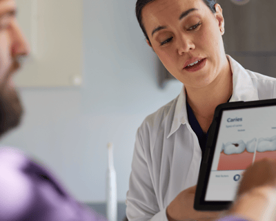 A dental professional holding the guide talks with patient