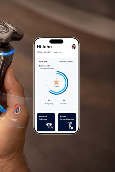 A hand holding a razor and next to it a display of the Male Grooming App