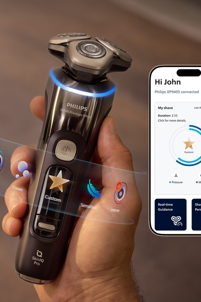 A hand holding a razor and next to it a display of the Male Grooming App
