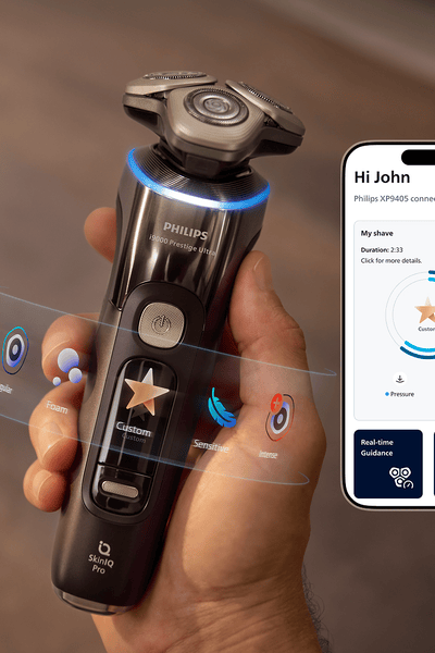 A hand holding a razor and next to it a display of the Male Grooming App