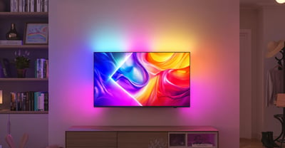 Televisor Philips Ambilight con luz colorida que se proyecta en la pared de una sala de estar