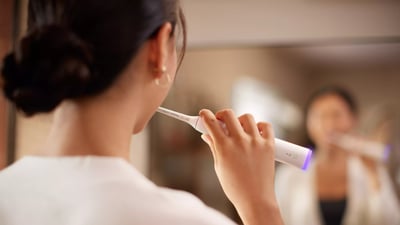 kobieta myjąca zęby szczoteczką soniczną Philips Sonicare