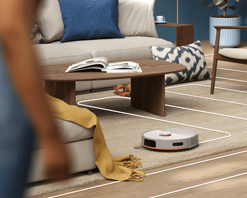 Robot-usisivač čisti tepih u dnevnoj sobi u pravim linijama