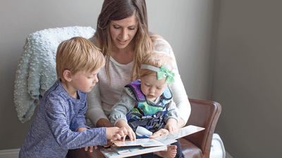 Părinte care îi citește copilului în balansoar