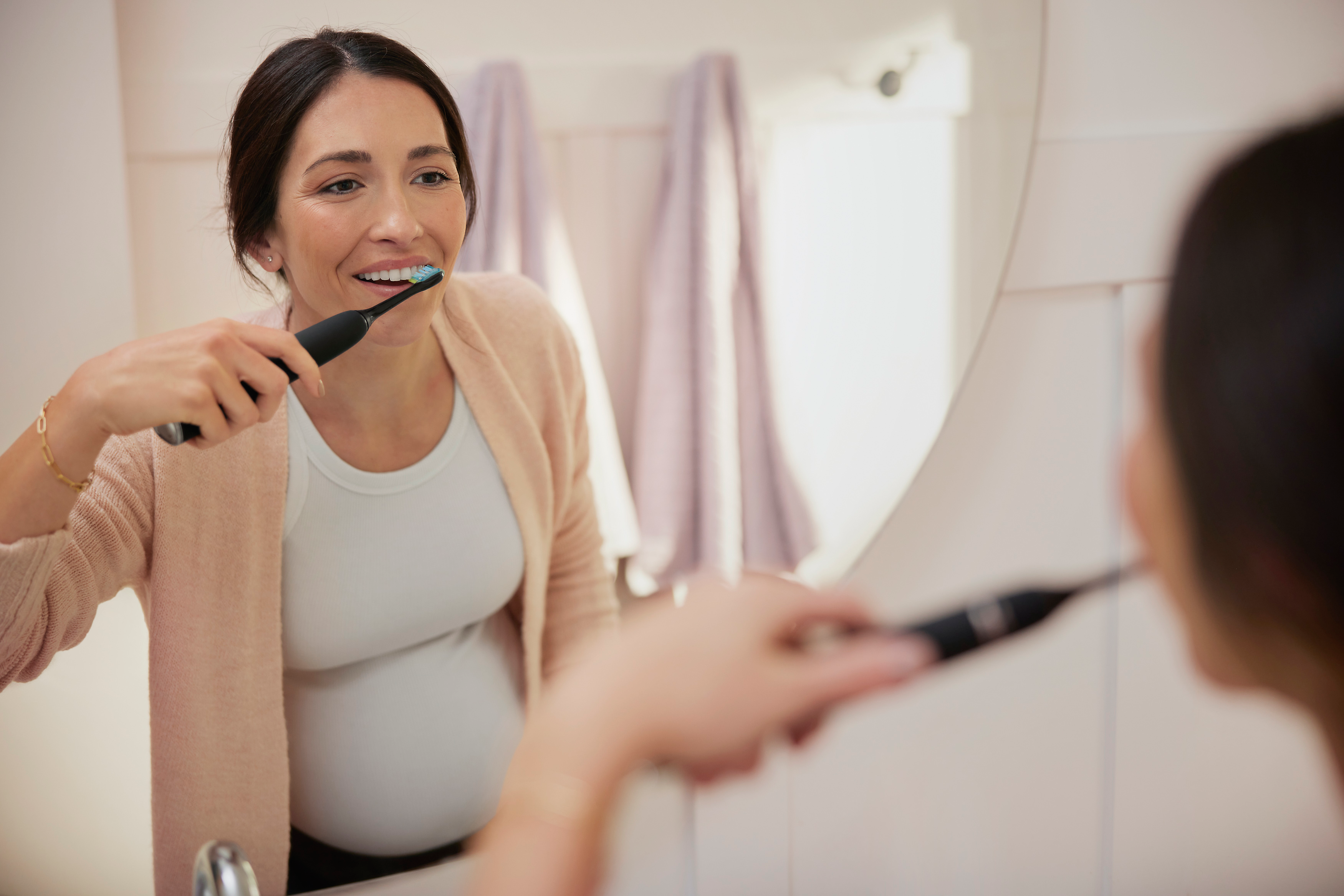 Вагітна жінка чистить зуби