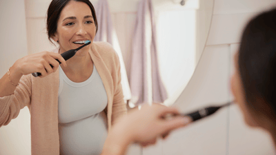 Вагітна жінка чистить зуби
