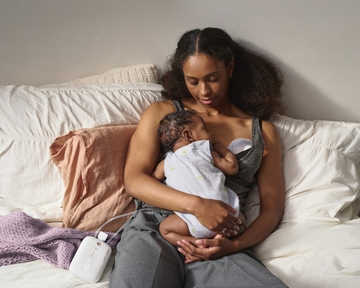 Mum on bed pumping with baby