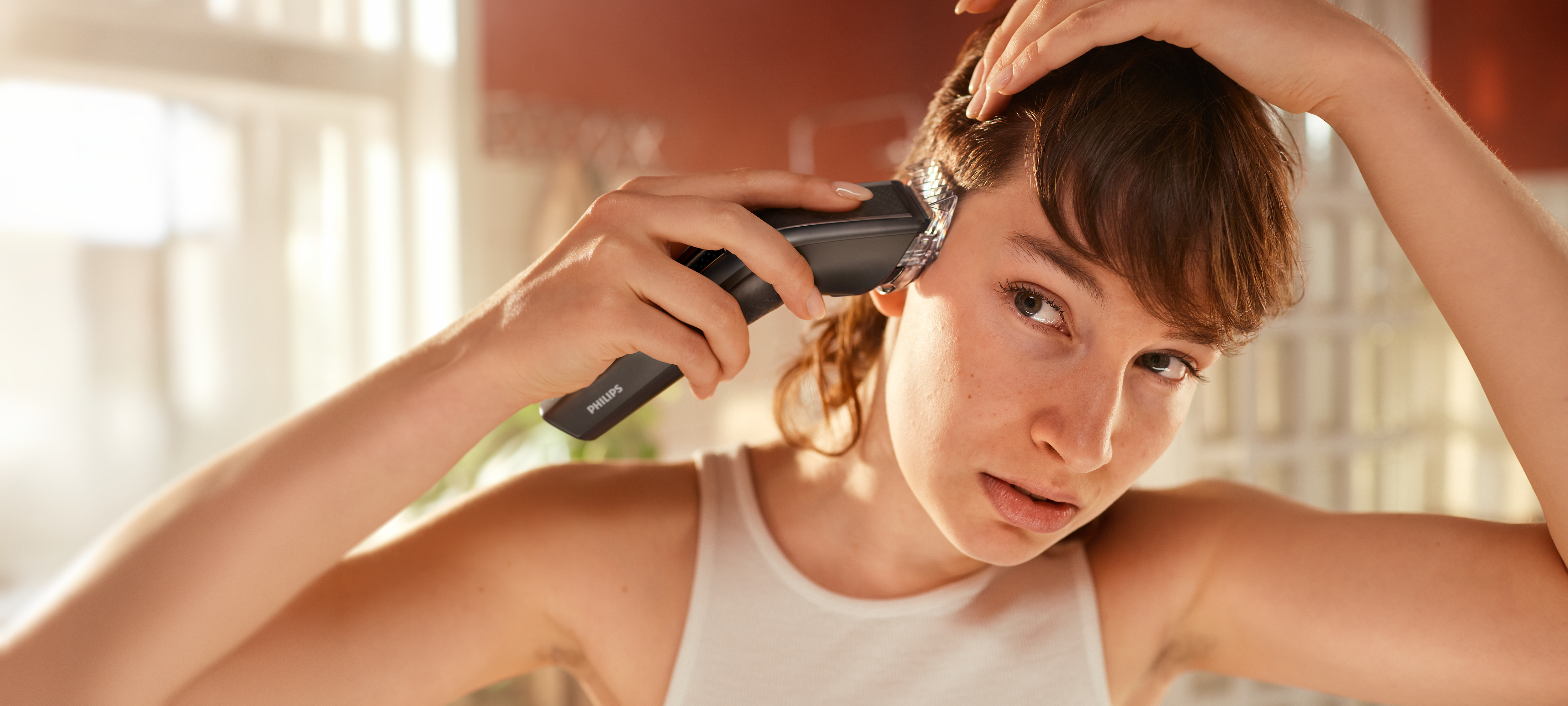 Man trimming his hair with the hair clipper