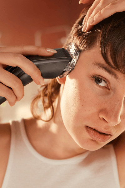 Man trimming his hair with the hair clipper