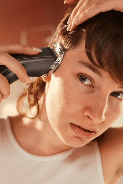 Man trimming his hair with the hair clipper