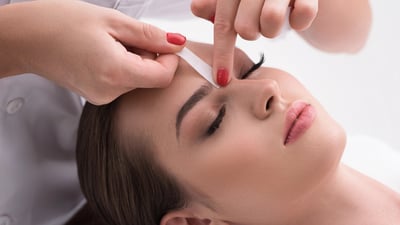 femeie-careia-i-se-contureaza-sprancenele-la-salon