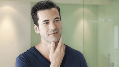 Bărbatul atingând ușor fața netedă