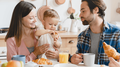Familie bucurându-se de masă împreună cu copilul mic