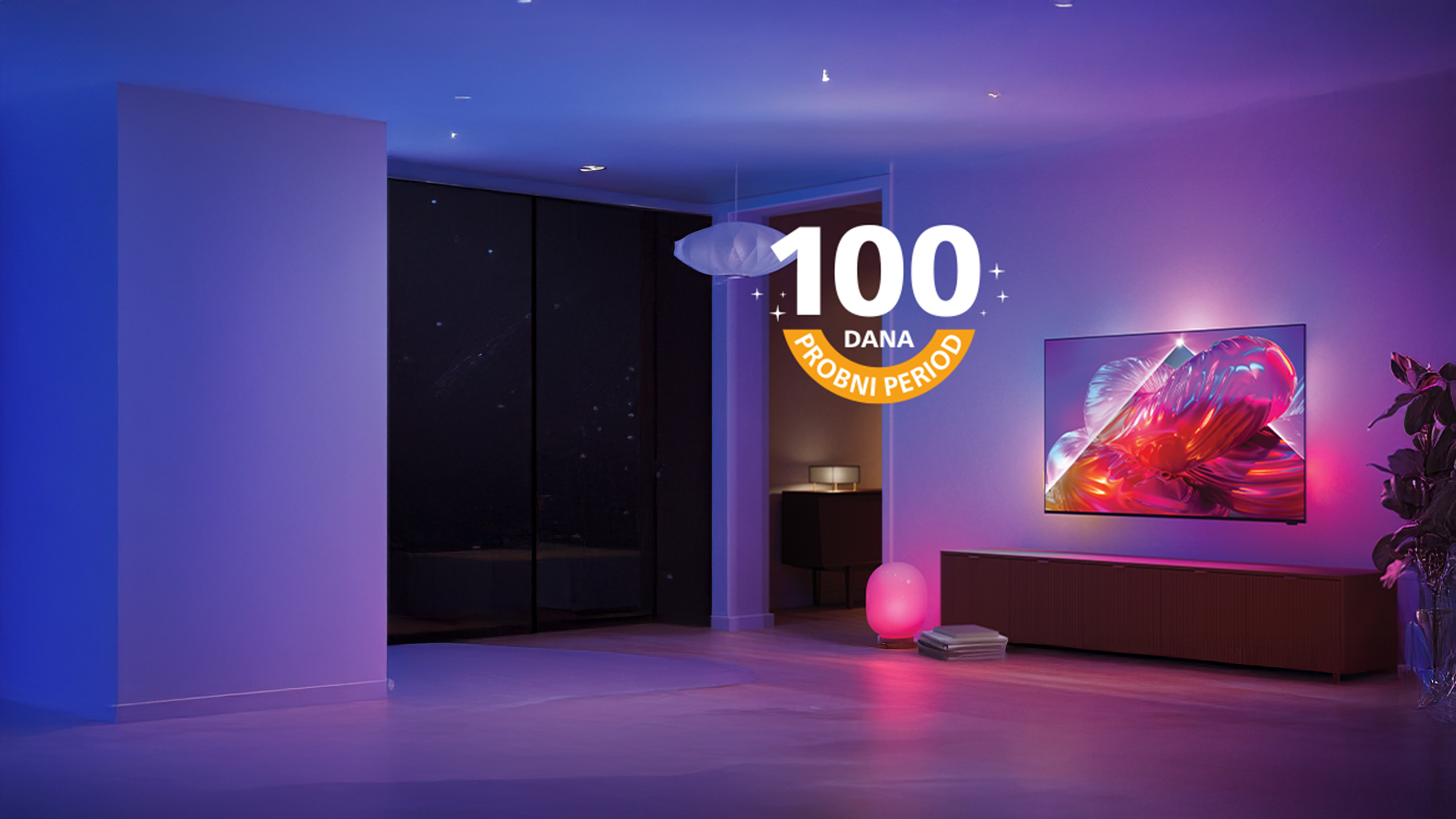 Philips Ambilight televizor postavljen na zid dnevnog boravka prikazuje živopisnu ružičastu umjetničku sliku, dok šareno ambijentalno osvjetljenje svijetli iza zaslona.