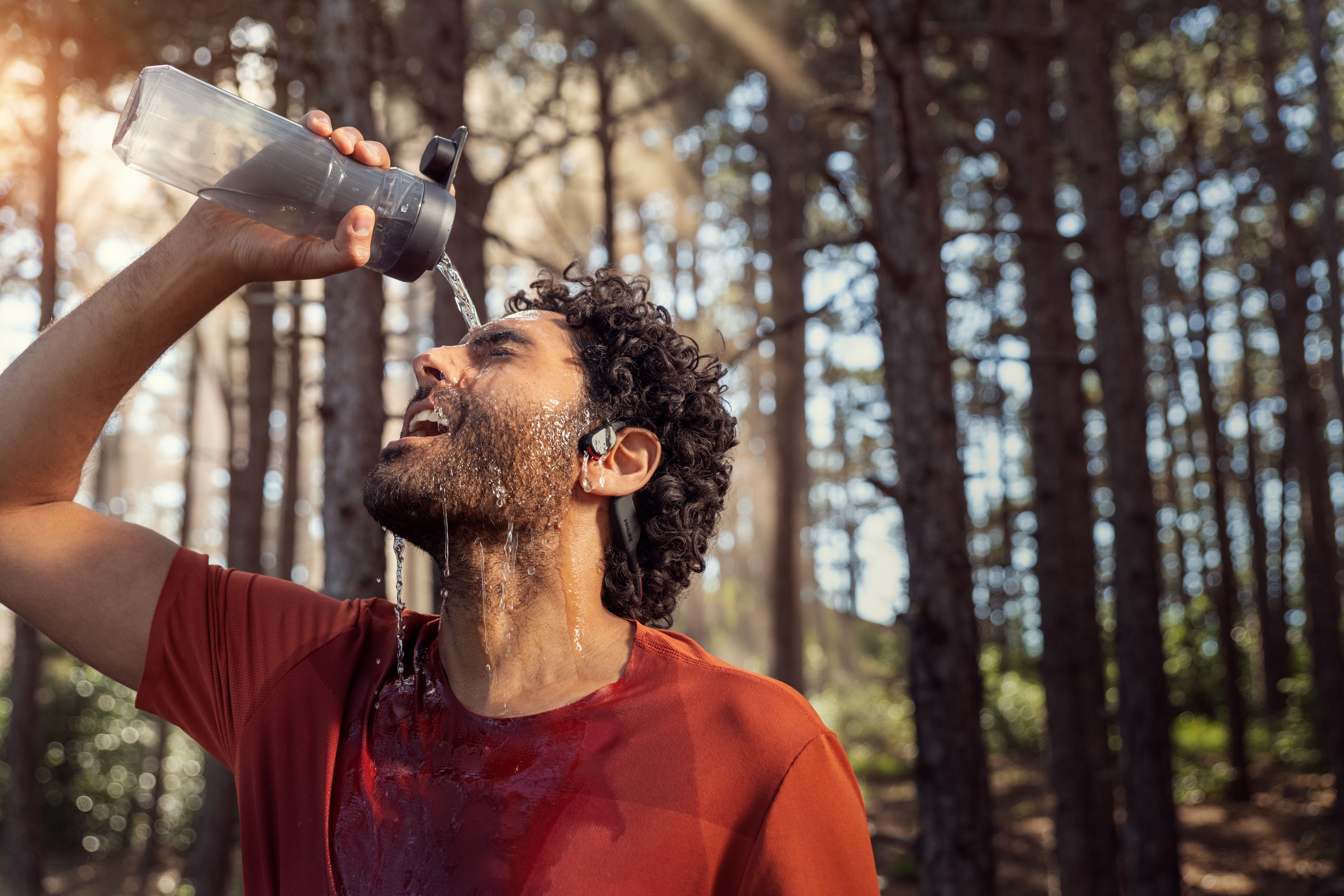 Muž používa bezdrôtové športové slúchadlá Philips počas tréningu vonku.